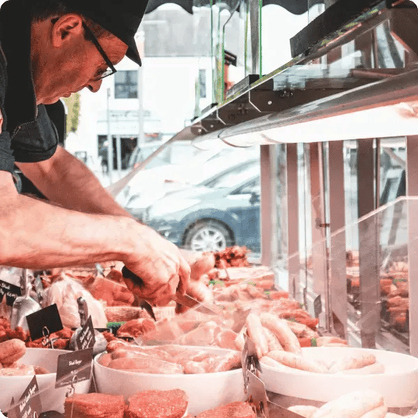 Local butcher inspecting meat case